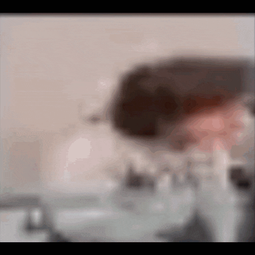 a blurry picture of a person washing their face in a bathroom