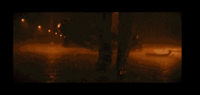 a silhouette of a person in a dark room with a car in the background