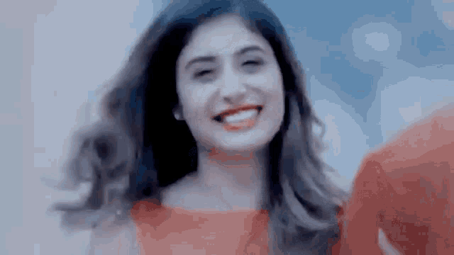a woman in a red dress is smiling for the camera while standing next to a man in a red shirt .