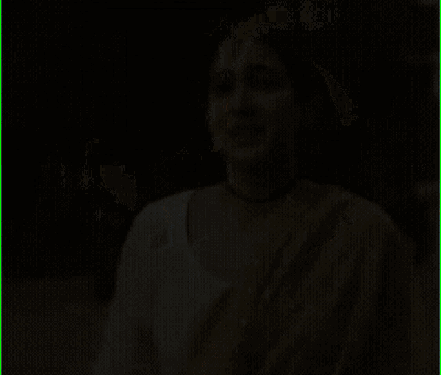 a woman wearing a white top and a yellow scarf is smiling