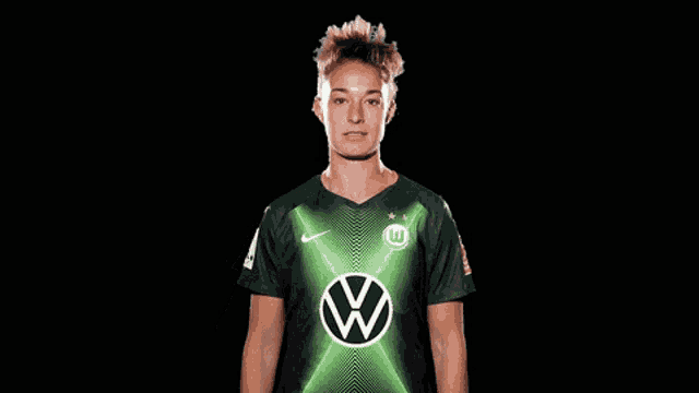 a woman wearing a green shirt with a vw logo on the front