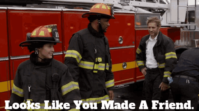two firefighters are standing in front of a red fire truck with the caption looks like you made a friend