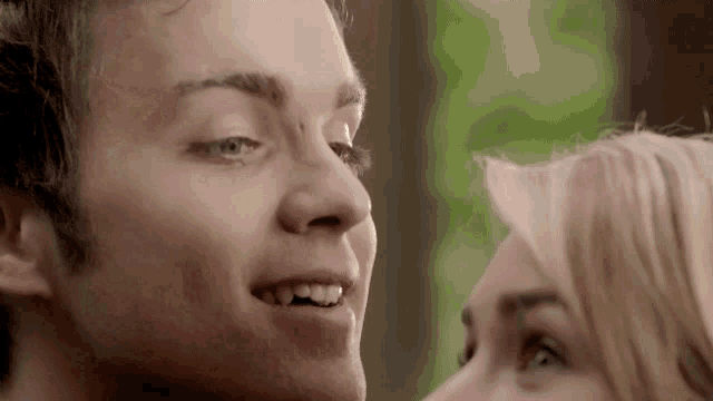 a close up of a man and a woman 's faces looking at each other