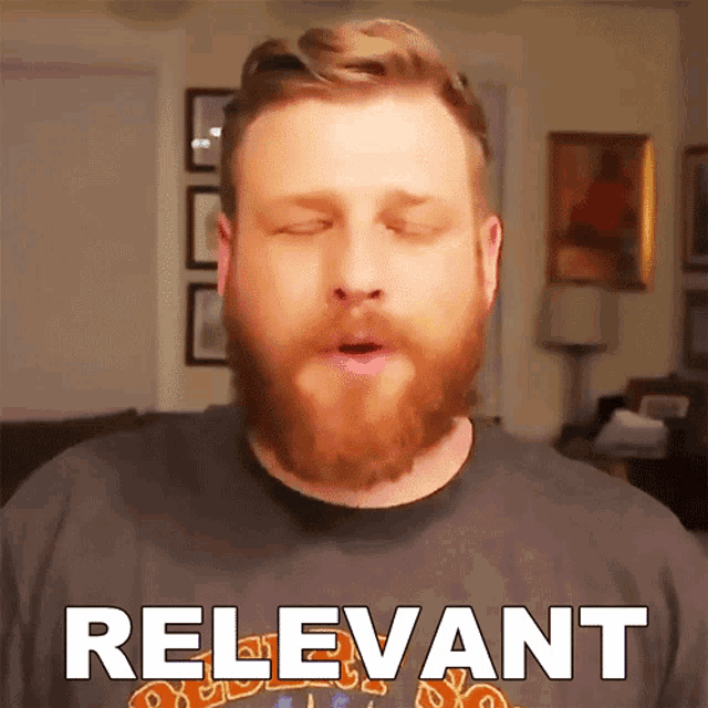a man with a beard is wearing a shirt that says relevant on it