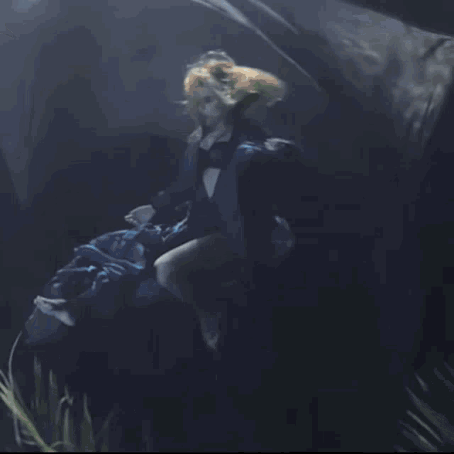 a woman in a blue dress is swimming in the water