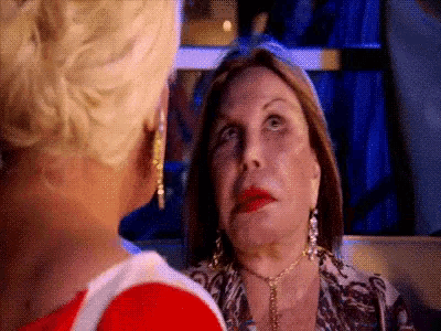 two women are standing next to each other and looking at each other 's faces .