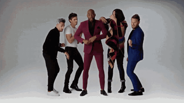 a man in a purple suit is surrounded by four other men