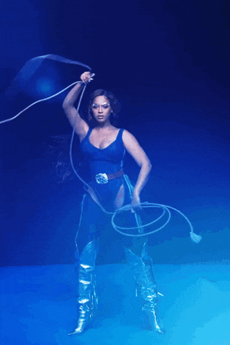 a woman in a blue outfit is holding a rope