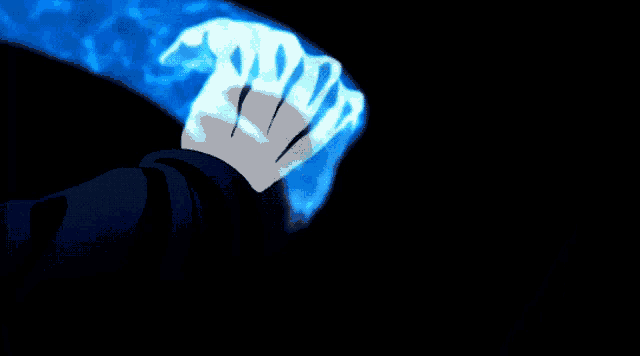 a person 's hand is glowing in the dark and holding a blue object .