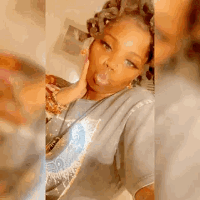 a woman is blowing a bubble while taking a selfie in a room .