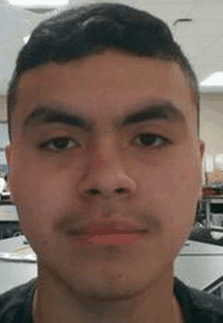 a close up of a young man 's face in an office .