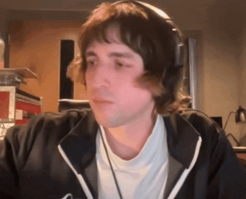 a man wearing headphones and a black jacket with a white shirt