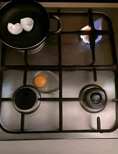 eggs are being cooked in a frying pan on a gas stove