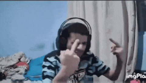 a young boy wearing headphones giving the middle finger