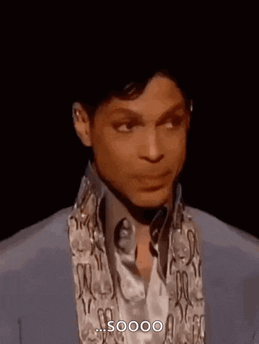 prince is wearing a blue jacket and a white shirt and making a funny face .