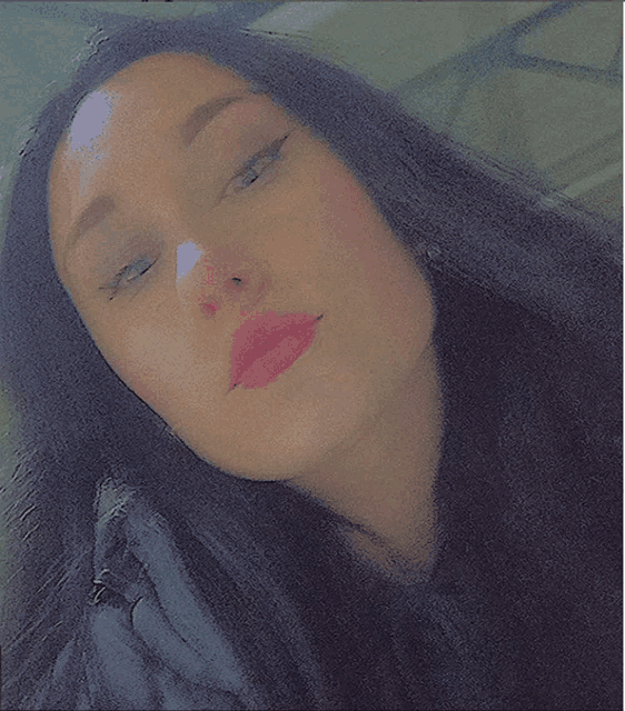 a close up of a woman 's face with long black hair and pink lips