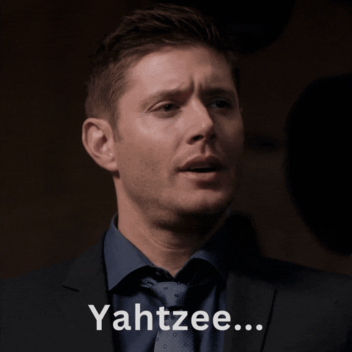 a man in a suit holds a bottle of beer and says " yahtzee "