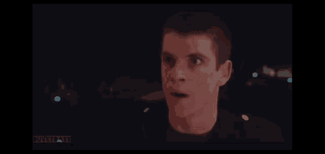 a close up of a man 's face with his mouth open in a movie scene .