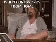 a man with a beard is sitting at a desk in front of a laptop computer .