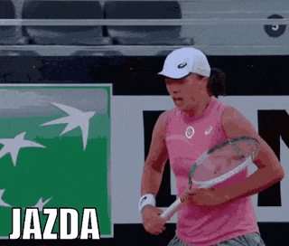 a woman in a pink tank top is holding a tennis racquet in front of a sign that says " jazda "