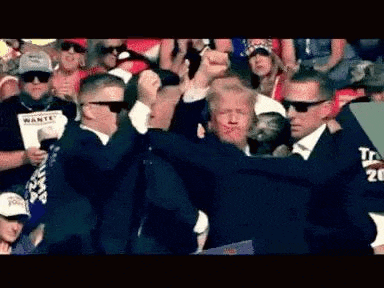 a group of men in suits are standing around a man in a suit .