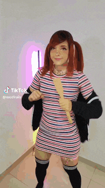 a woman in a striped dress is holding a wooden spatula