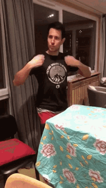 a man wearing a black shirt that says ' your organic clothing ' on it