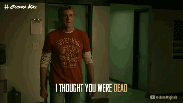 a man wearing a red shirt that says speed king