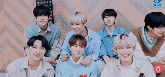 a group of young men are posing for a picture and one of them is wearing a sweater with a heart on it .