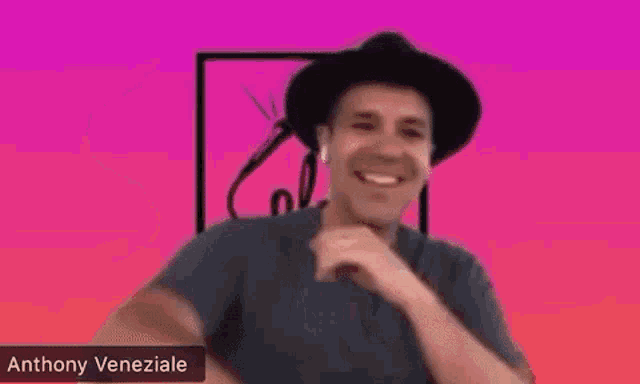 a man wearing a hat and headphones is making a funny face while talking on a video call .
