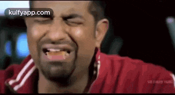 a man with a beard is making a funny face while sitting in a car with his eyes closed .