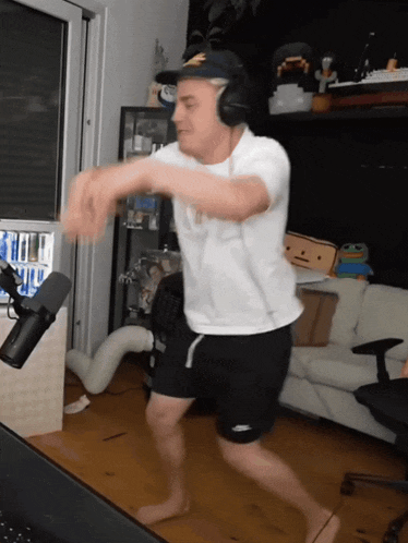 a man in a white shirt and black shorts is dancing