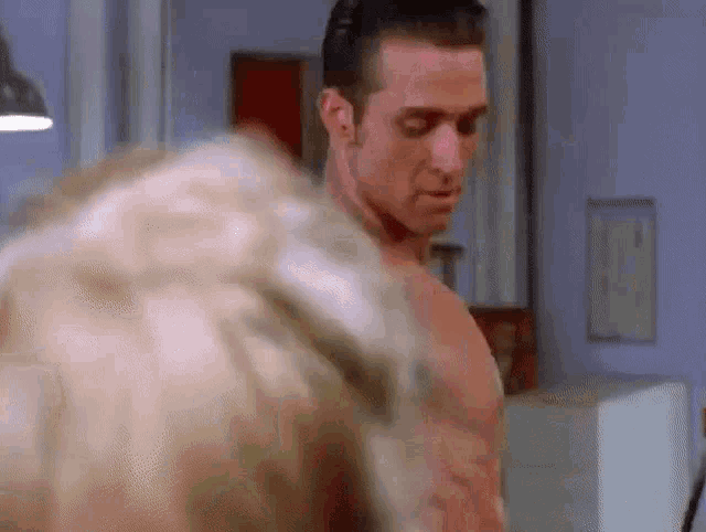 a shirtless man is standing next to a woman .