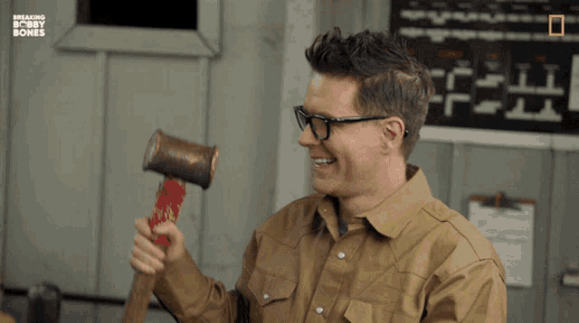 a man with glasses is holding a hammer and says " i 'll take what i can get at this point "