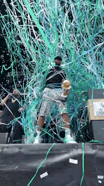 a man holding a trophy in front of a podium that says ' 2021 champions ' on it