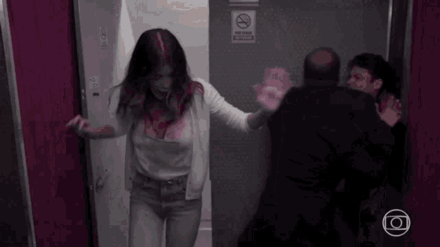 a woman is walking through a doorway with a no smoking sign on it