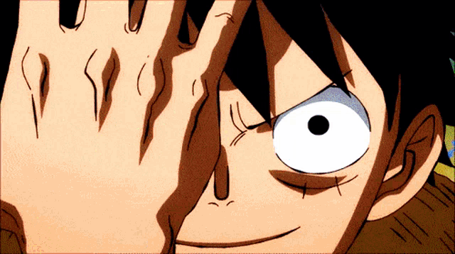 a close up of a person covering their eyes with their hand