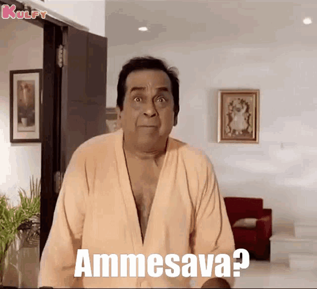 a man in a robe is standing in a living room and says " ammesava "