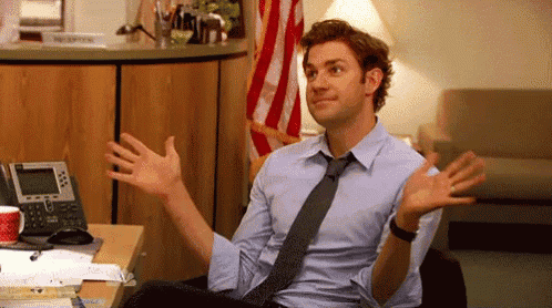 a man in a blue shirt and tie is sitting at a desk .