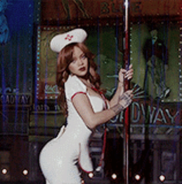 a woman dressed as a nurse is standing on a pole