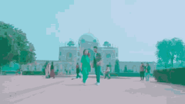 a man and a woman walking in front of a large building