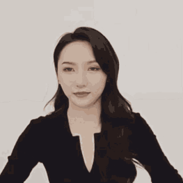 a woman is making a heart with her hands .