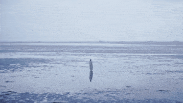 a person stands in the middle of a body of water