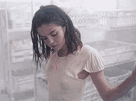 a woman in a white shirt is standing in a room with a lot of shelves .