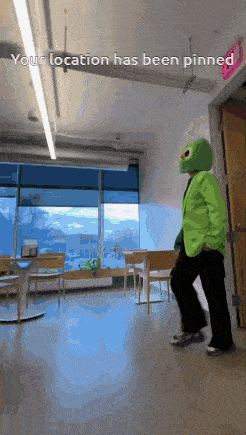 a person in a green suit and mask is walking in a room with the words " your location has been pinned " on the bottom