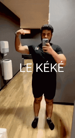 a man is taking a picture of himself in a mirror with the words le keke on the bottom right