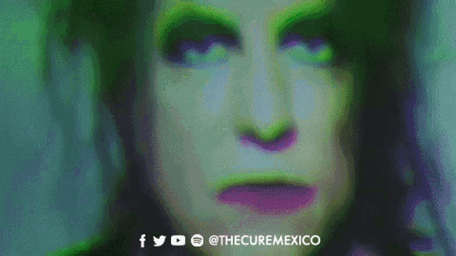a close up of a woman 's face with green makeup