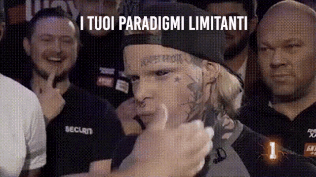 a man with a tattoo on his face is giving a thumbs up in front of a crowd ..