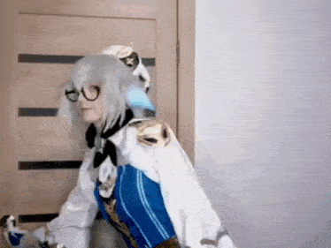 a woman in a cosplay costume is standing next to a door .