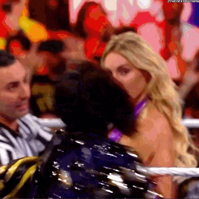a man and a woman are hugging each other in a crowd .